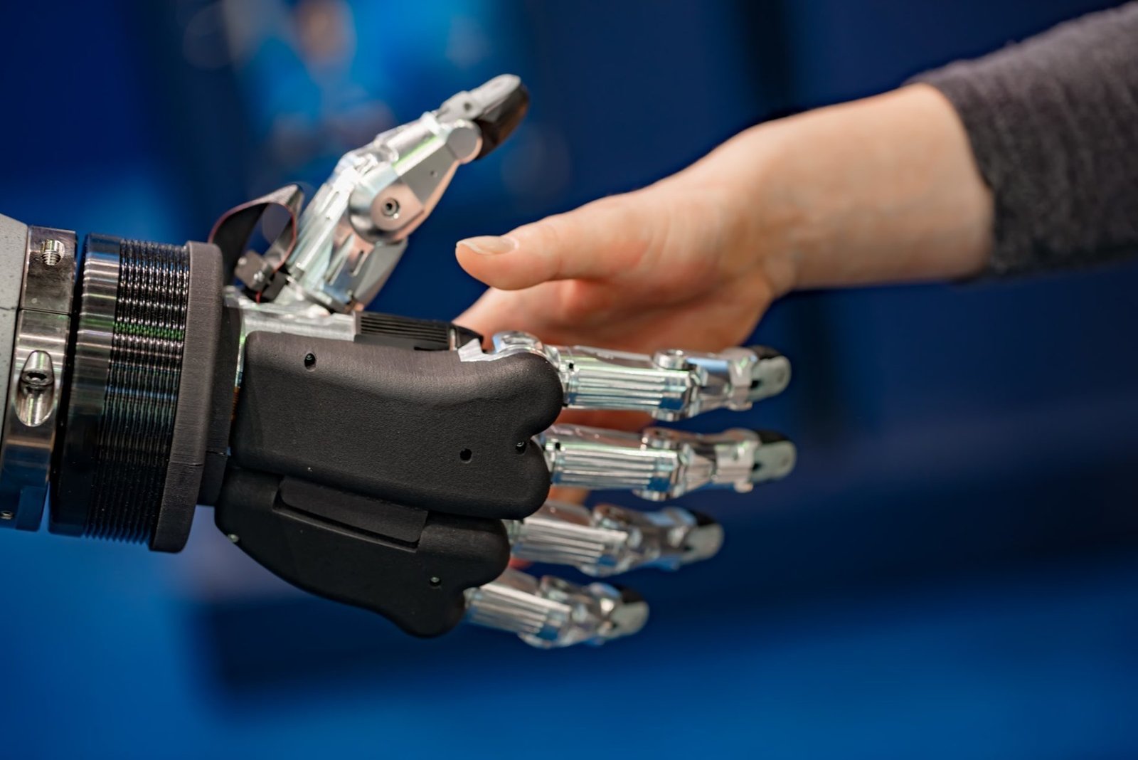Hand of a businesswoman shaking hands with a Android robot.