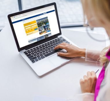 cropped view of woman using laptop with booking website